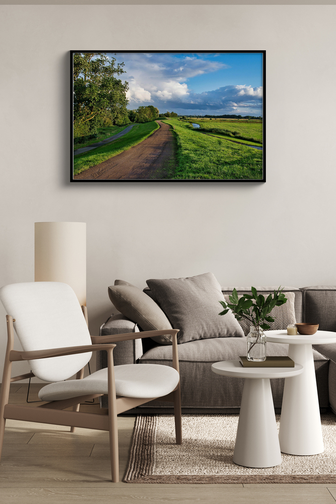 Photo de paysage sur plexiglas avec cadre noir au-dessus d’un canapé, près d’un fauteuil clair dans un salon