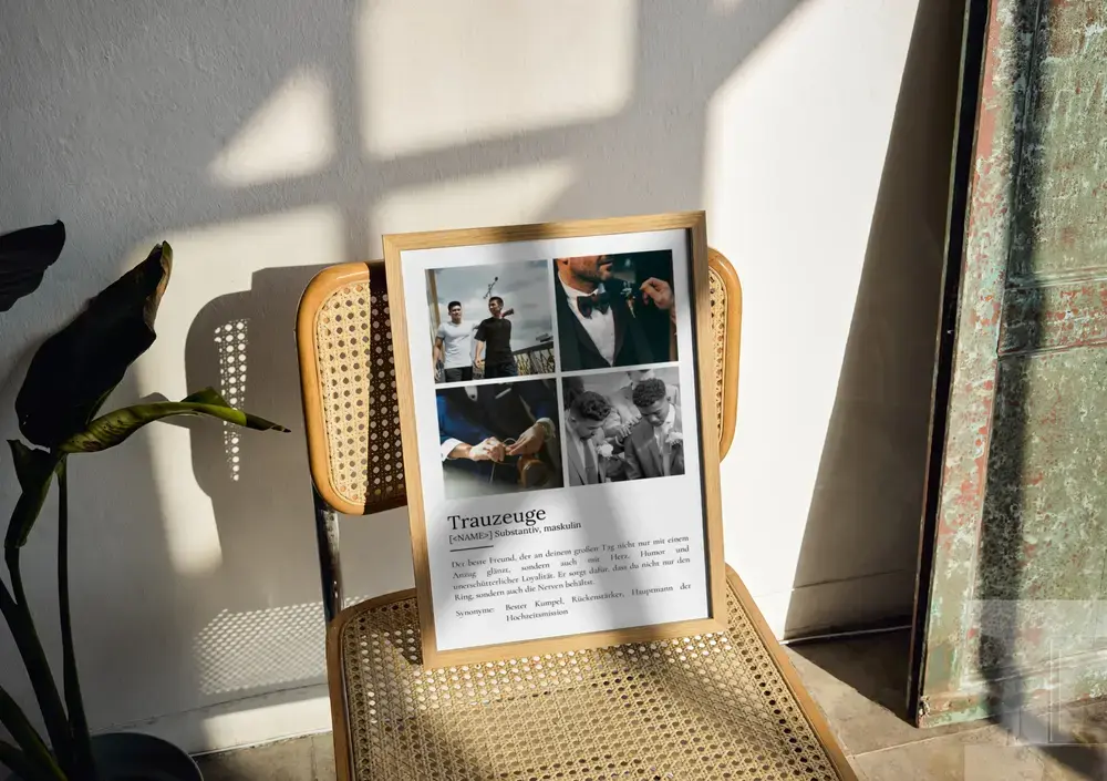 Trauzeugen-Definitionsposter mit vier Fotos im Naturholzrahmen auf einem Geflechtstuhl im Sonnenlicht