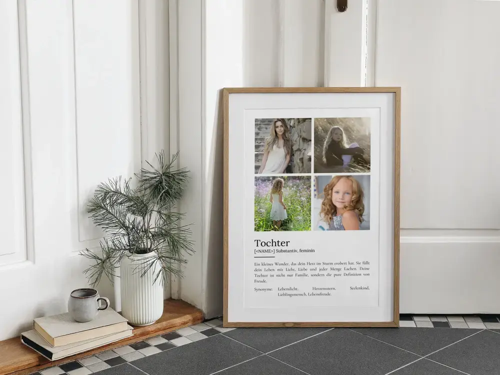 Definitionsposter für die Tochter mit vier Fotos im Holzrahmen, am Boden neben Büchern und einer Vase