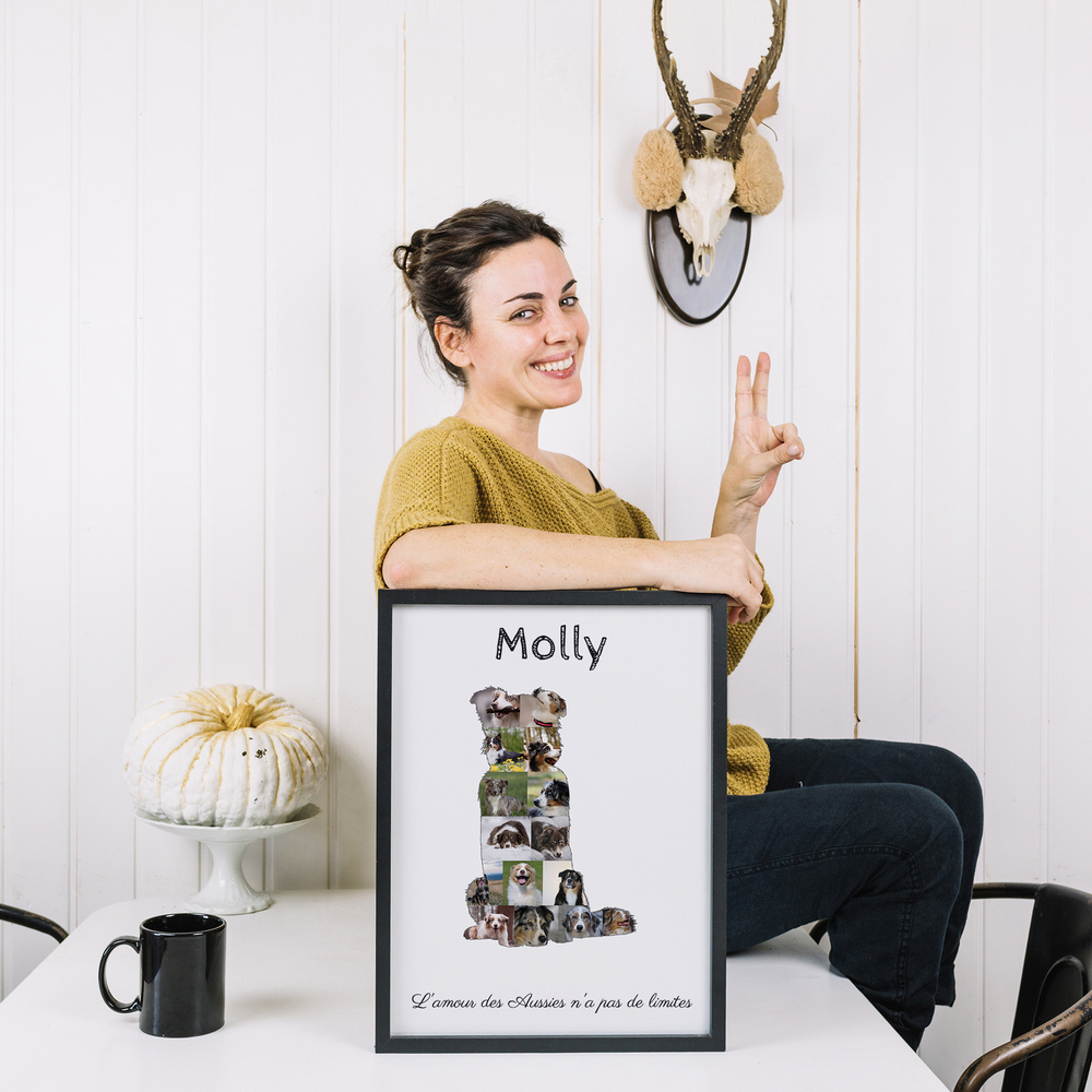 Pêle-mêle photo en forme de berger australien assis, avec nom et texte, dans un cadre noir posé sur une table.