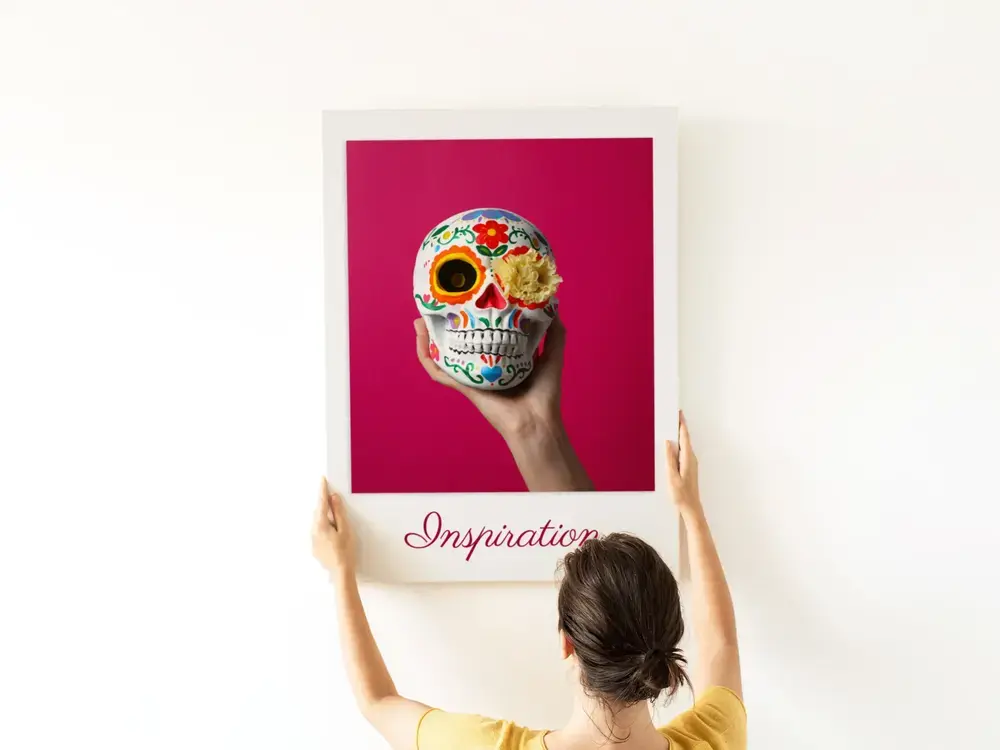 Individuelles Fotoposter mit buntem Totenkopf auf Pink und Wunschtext, hochkant an einer weißen Wand