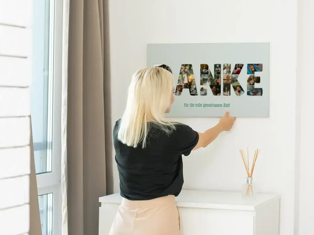Fotocollage-Poster mit Buchstaben aus Fotos als Jubiläumsgeschenk, an heller Wand über einer weißen Kommode