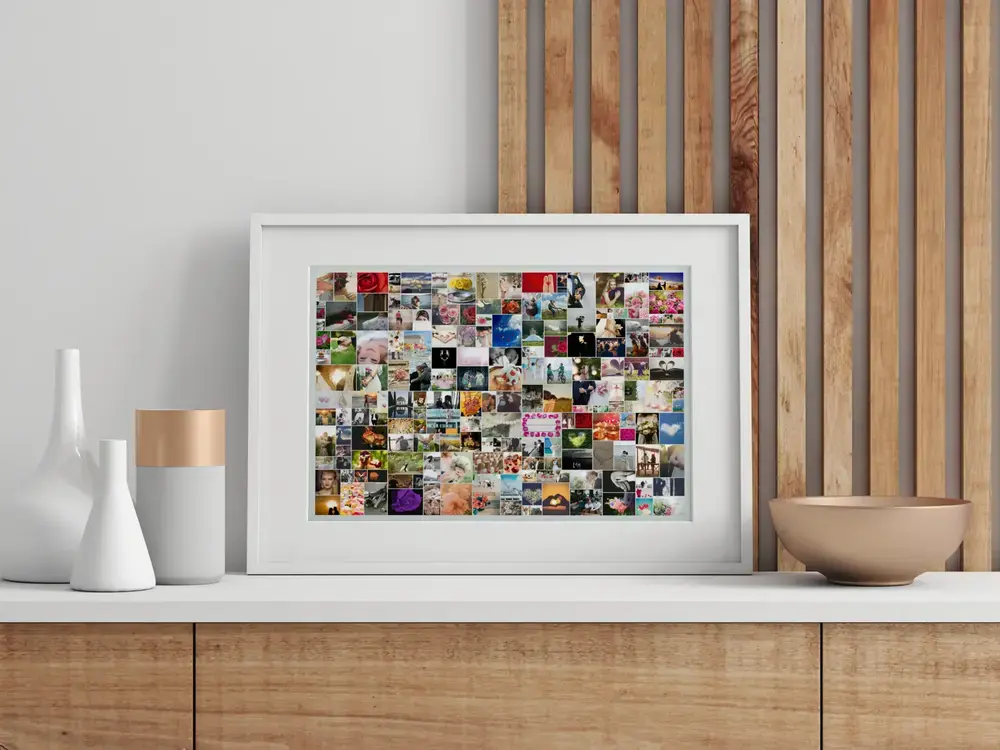 Fotocollage mit vielen Hochzeitsmotiven im weißen Rahmen auf dem Sideboard, eine Geschenkidee fürs Brautpaar