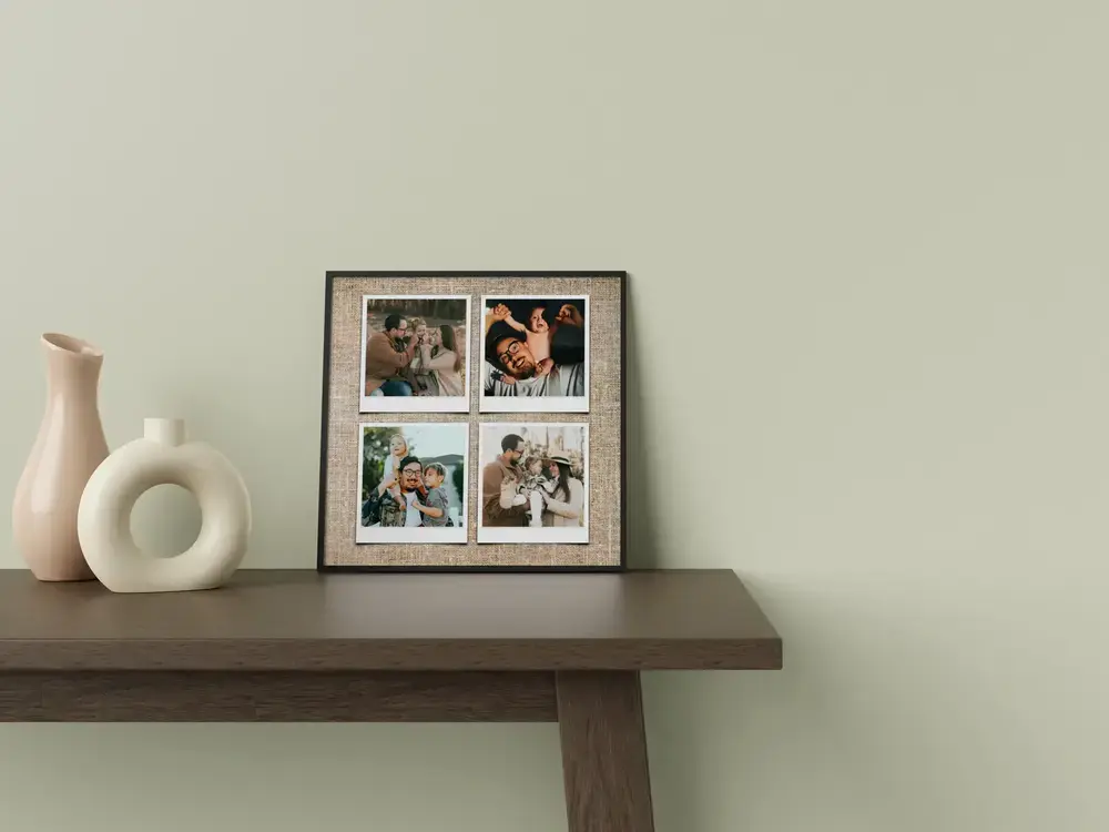 Gerahmte Familien-Fotocollage mit vier Bildern im Polaroid-Stil auf Leinenoptik, auf einem Tisch neben weißen Vasen